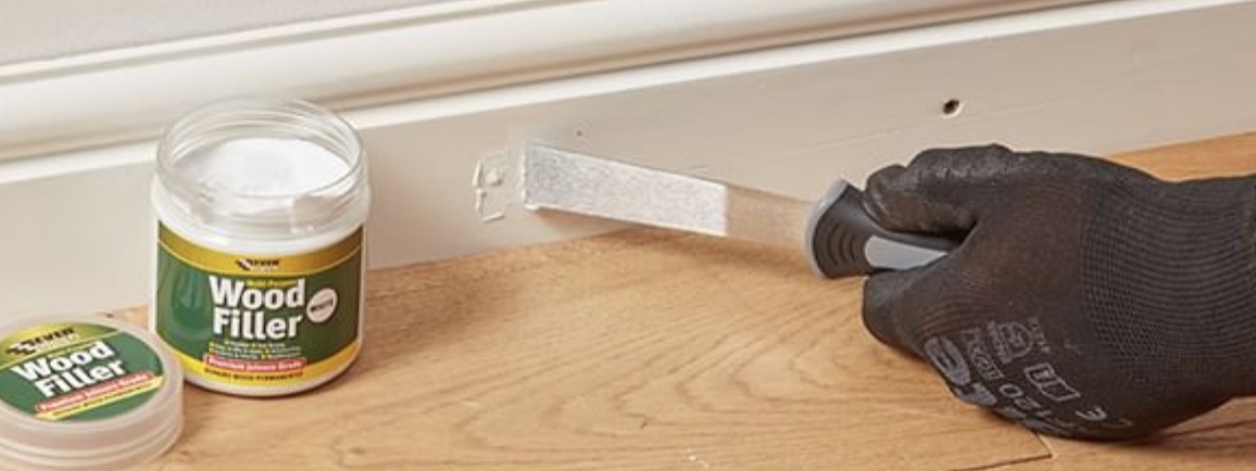 Using wood putty to fill nail holes in cabinet wood